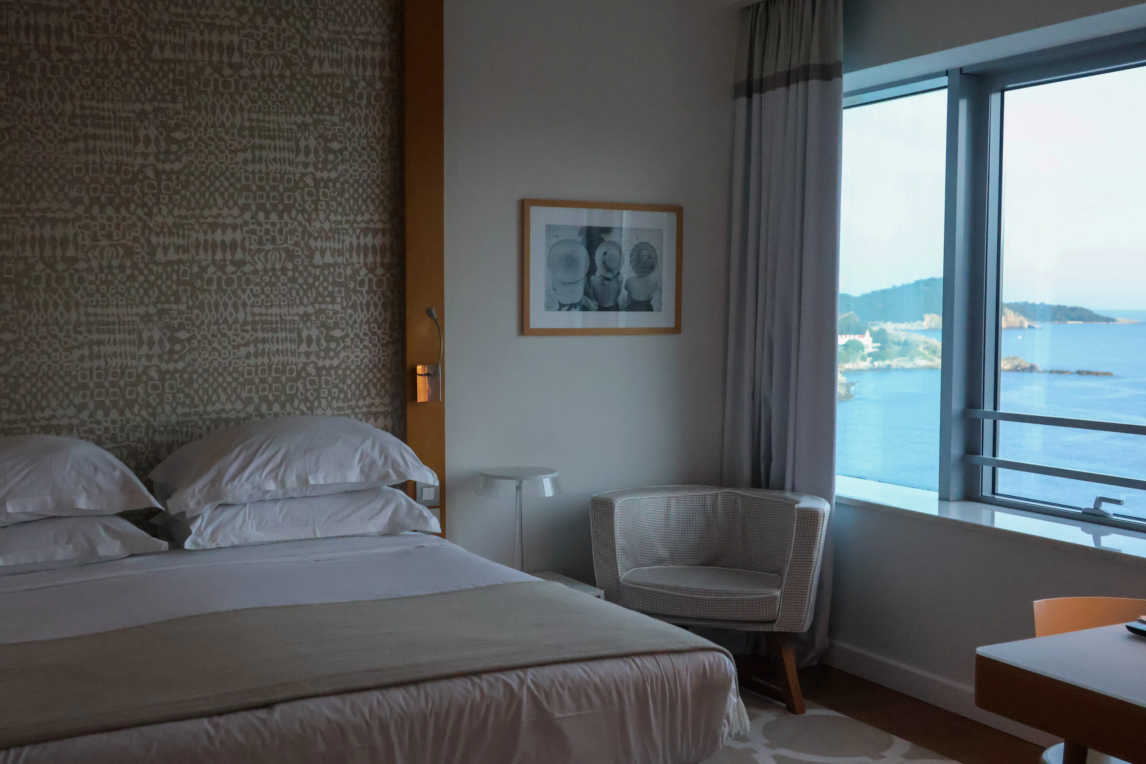 Hotel bedroom with a large bed and a window onto the water