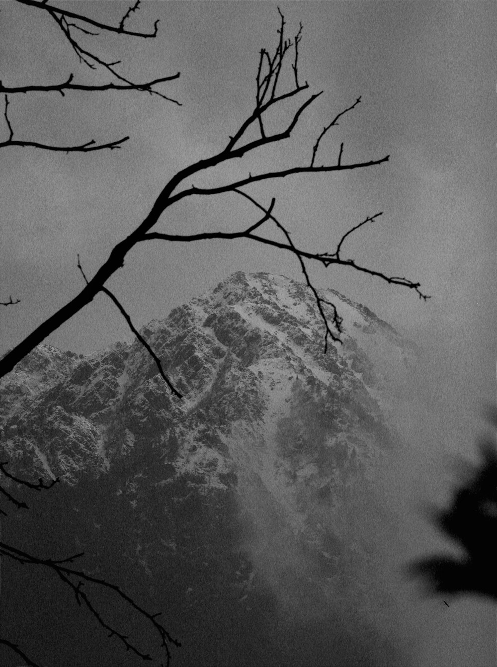 a black and white photo of a snowy mountain