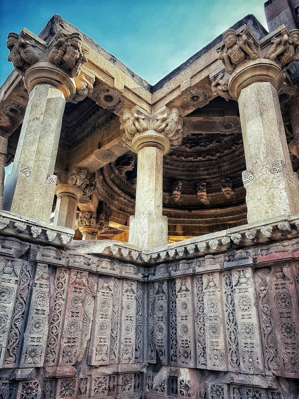 une structure en pierre avec des piliers et des sculptures dessus