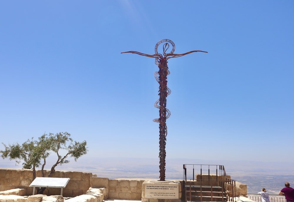 a tall metal sculpture on top of a hill