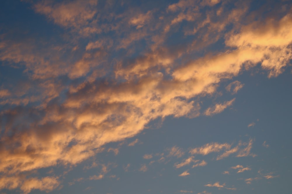 a plane flying in the sky at sunset