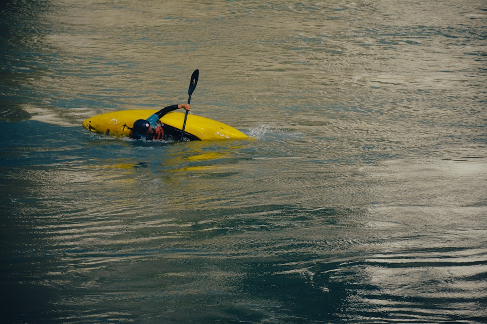 a person in a yellow kayak paddling through the water
