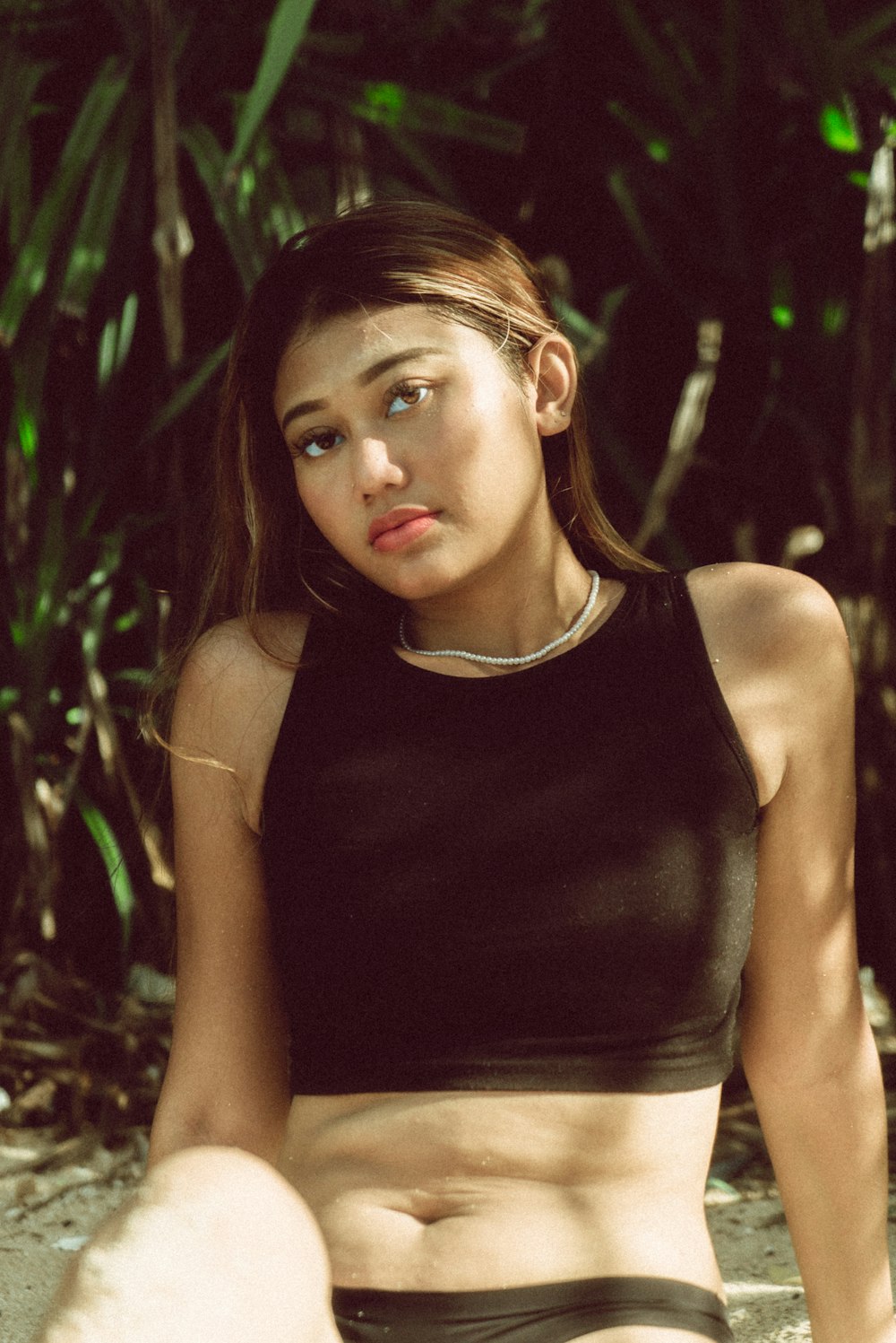 a woman sitting on the ground in a black top