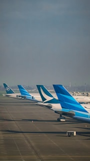 a row of airplanes sitting on top of an airport tarmac
