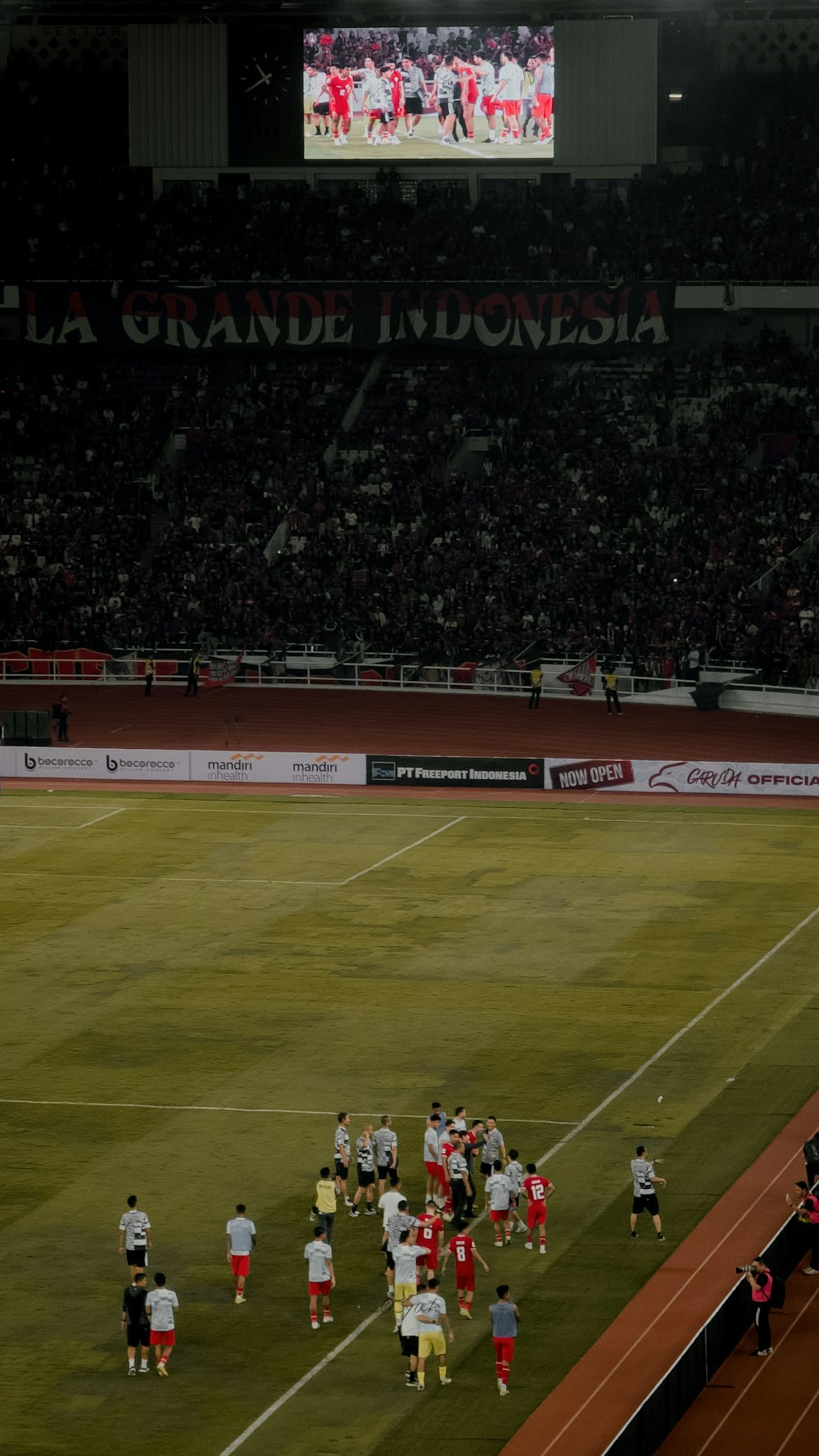 a group of people standing on top of a soccer field