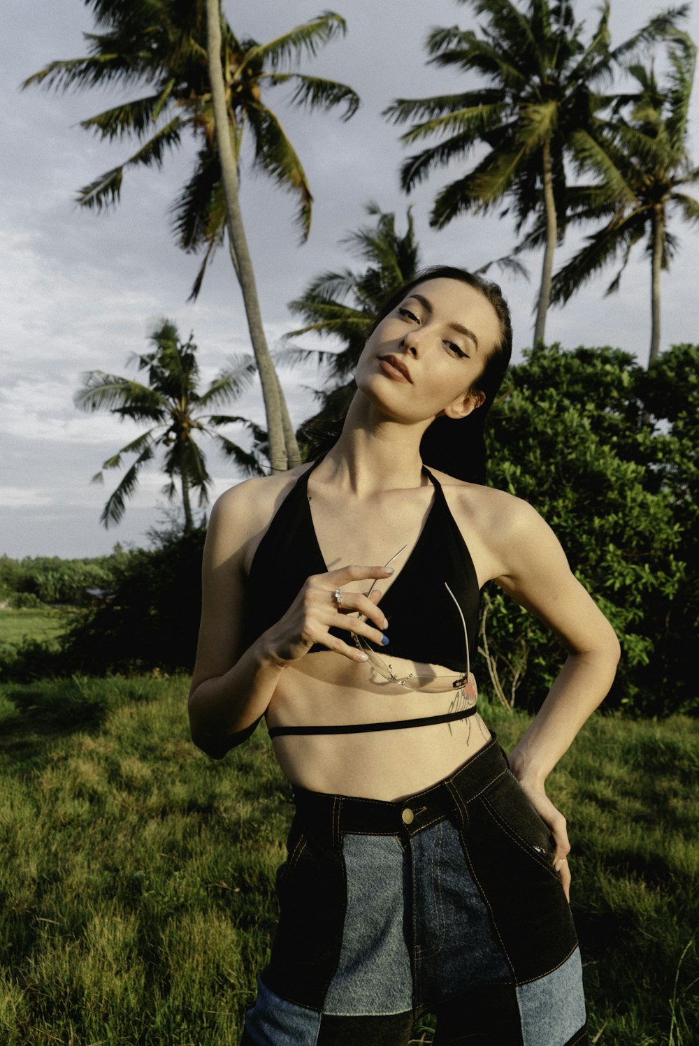 a woman standing in the grass with her hands on her hips