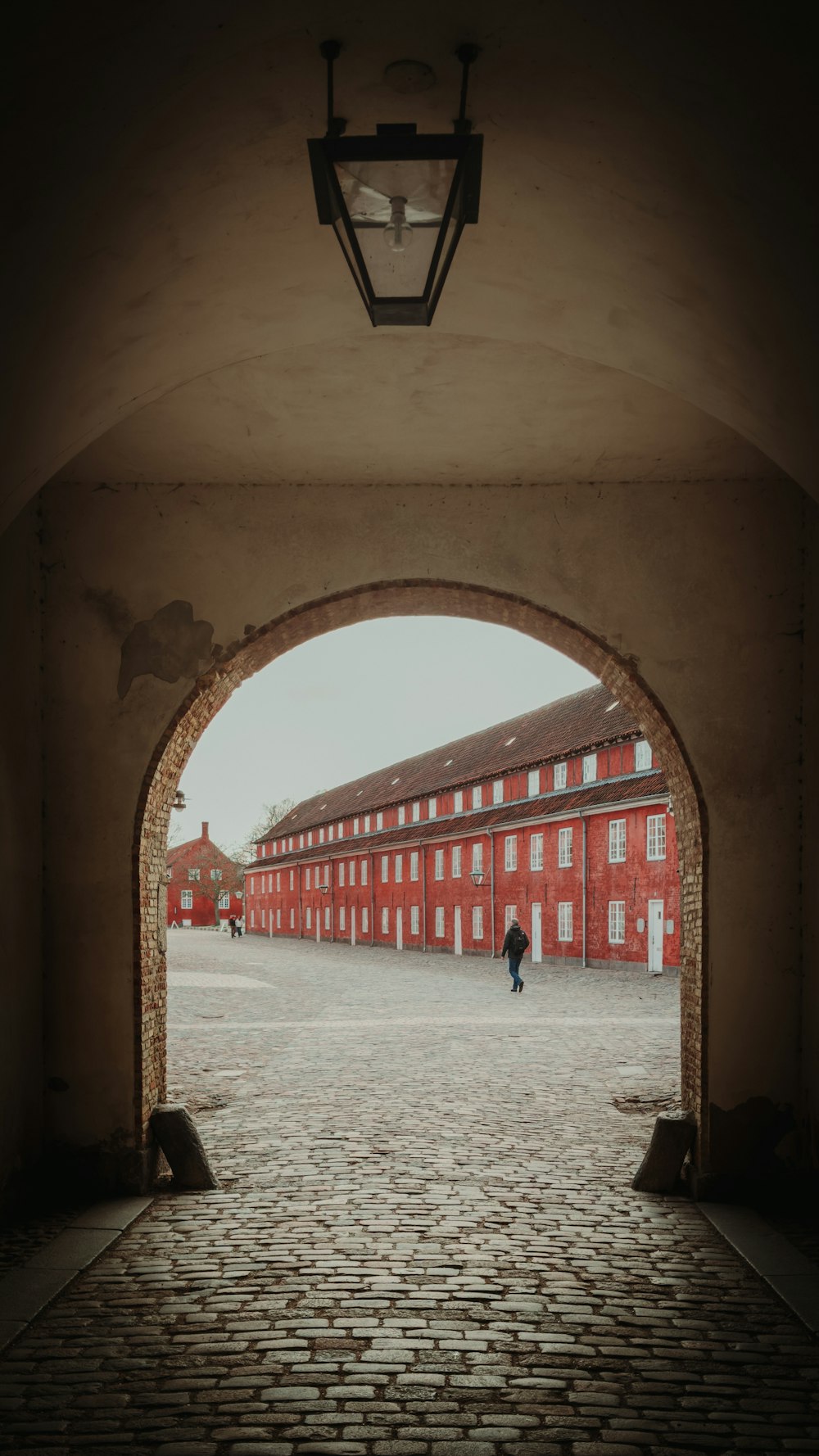 a person walking through an archway in a brick building