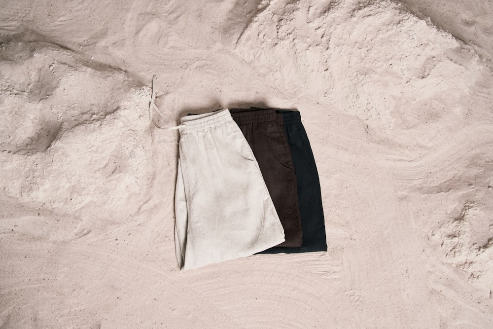 a pair of pants laying on top of a sandy beach