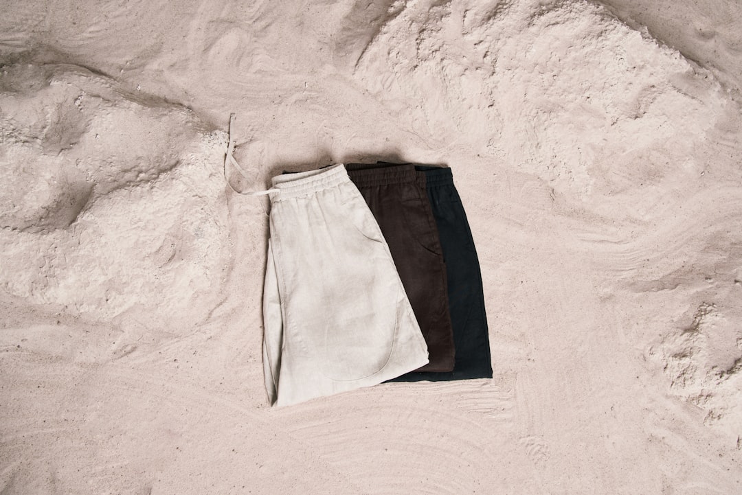 a pair of pants laying on top of a sandy beach,