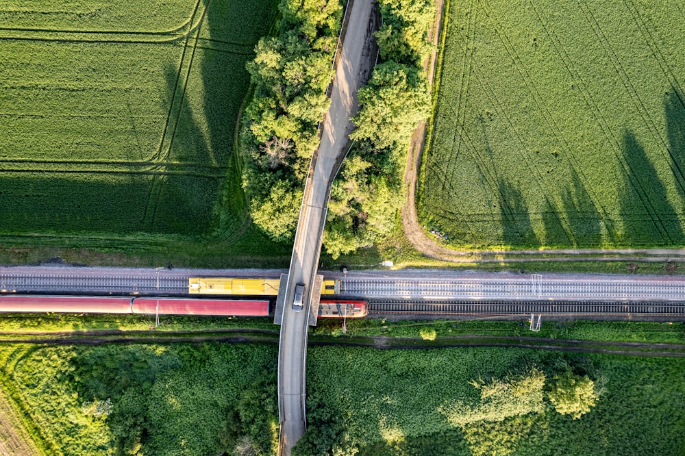 an aerial view of a train crossing a road