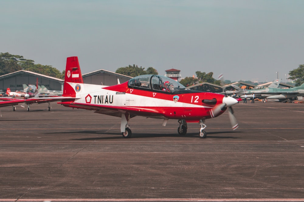 a small red and white plane on a runway