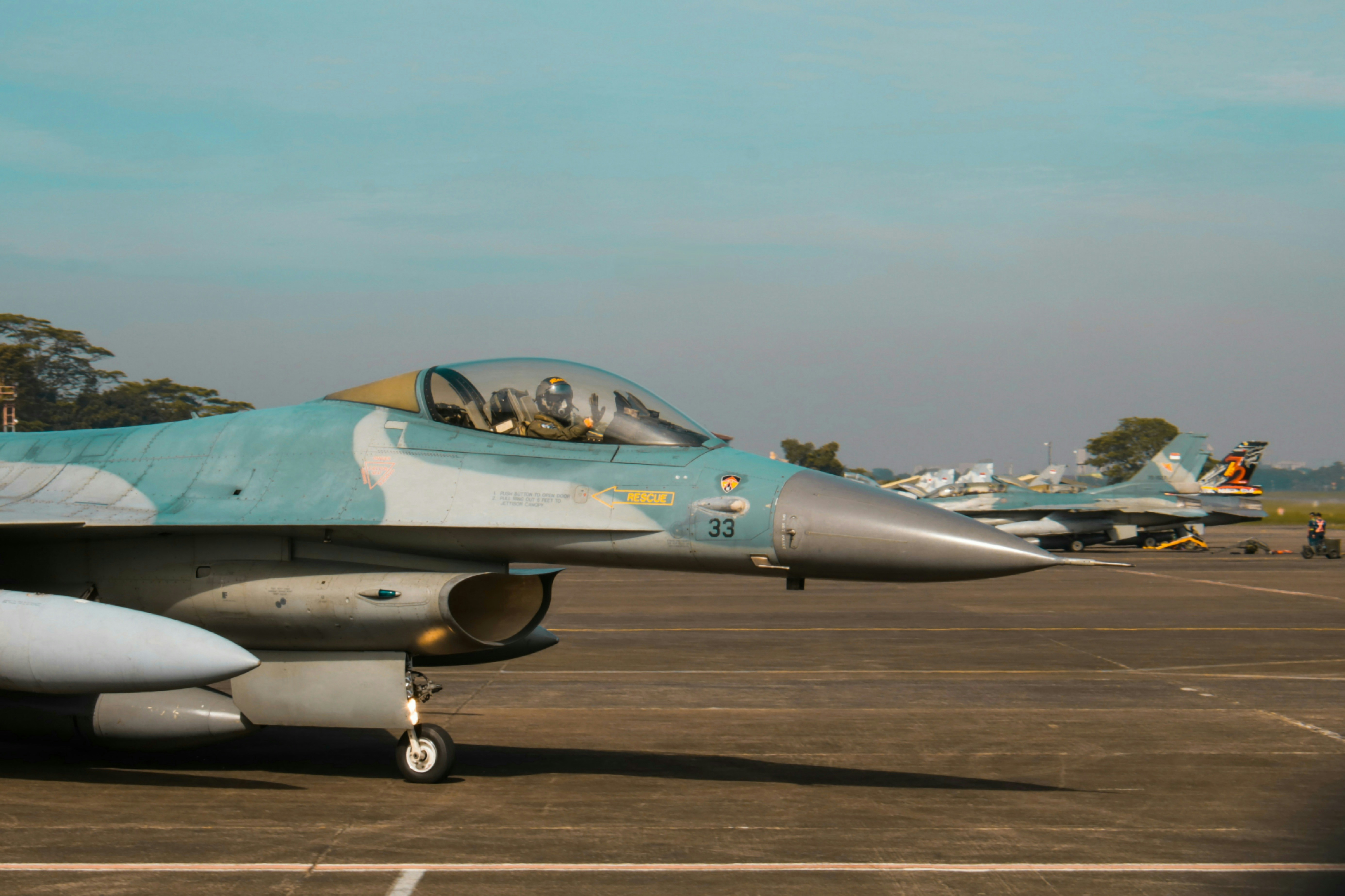 a fighter jet sitting on top of an airport tarmac