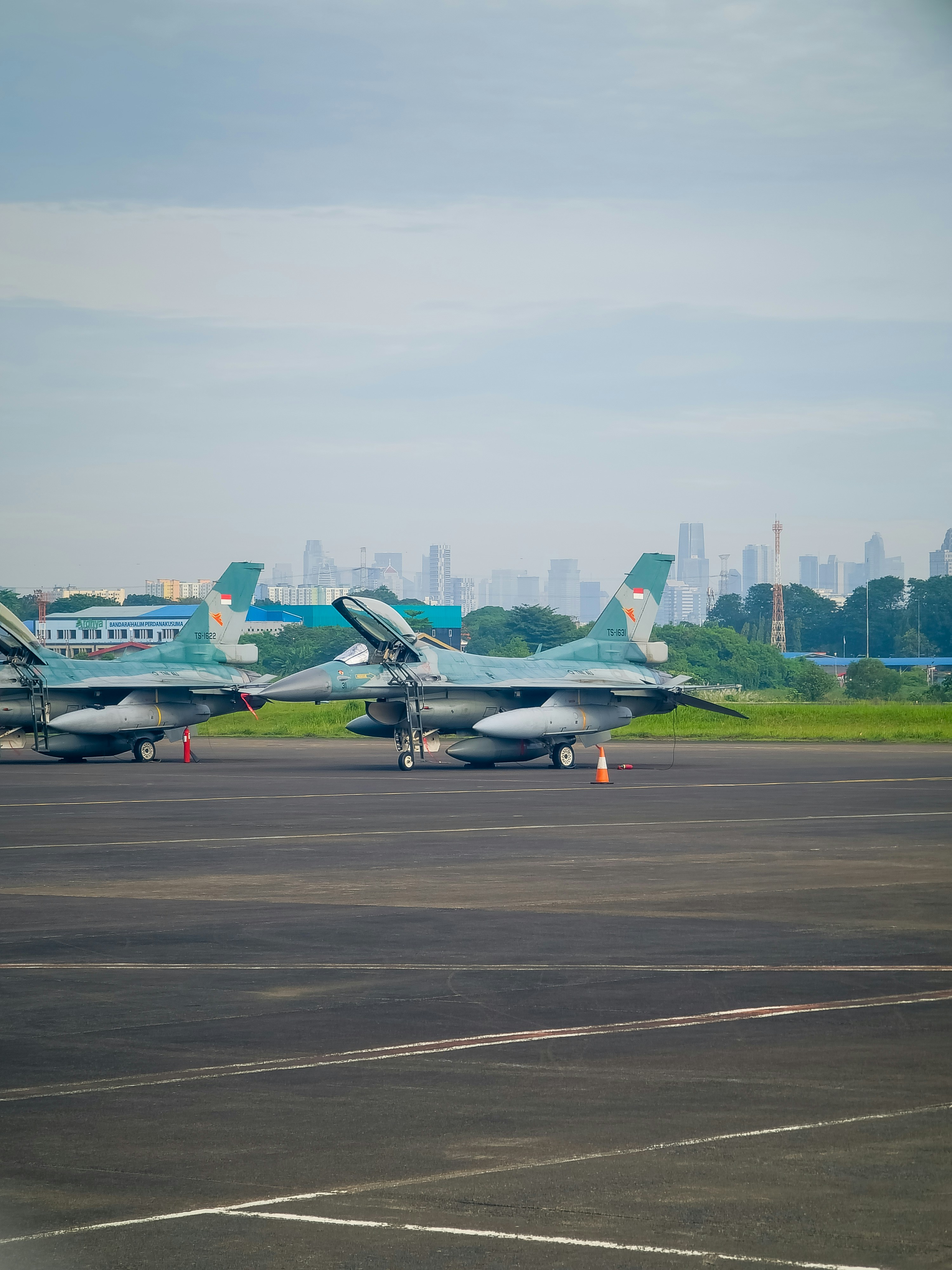a couple of fighter jets sitting on top of an airport runway
