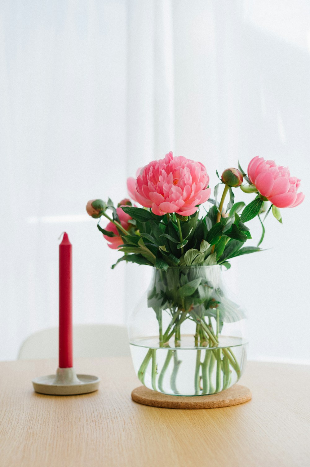 a vase with flowers and a candle on a table