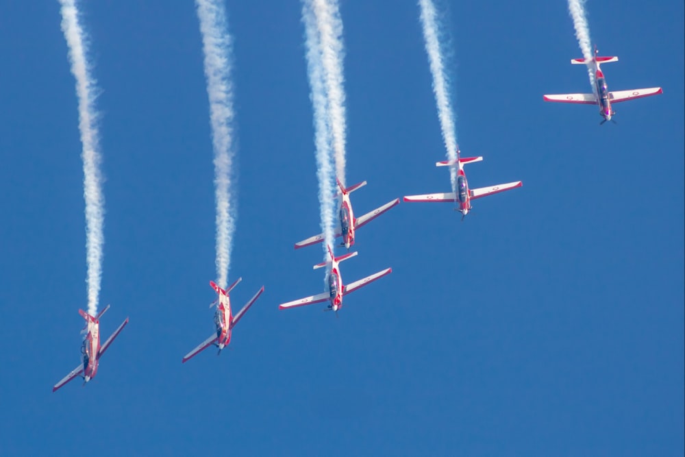 a group of airplanes flying through a blue sky