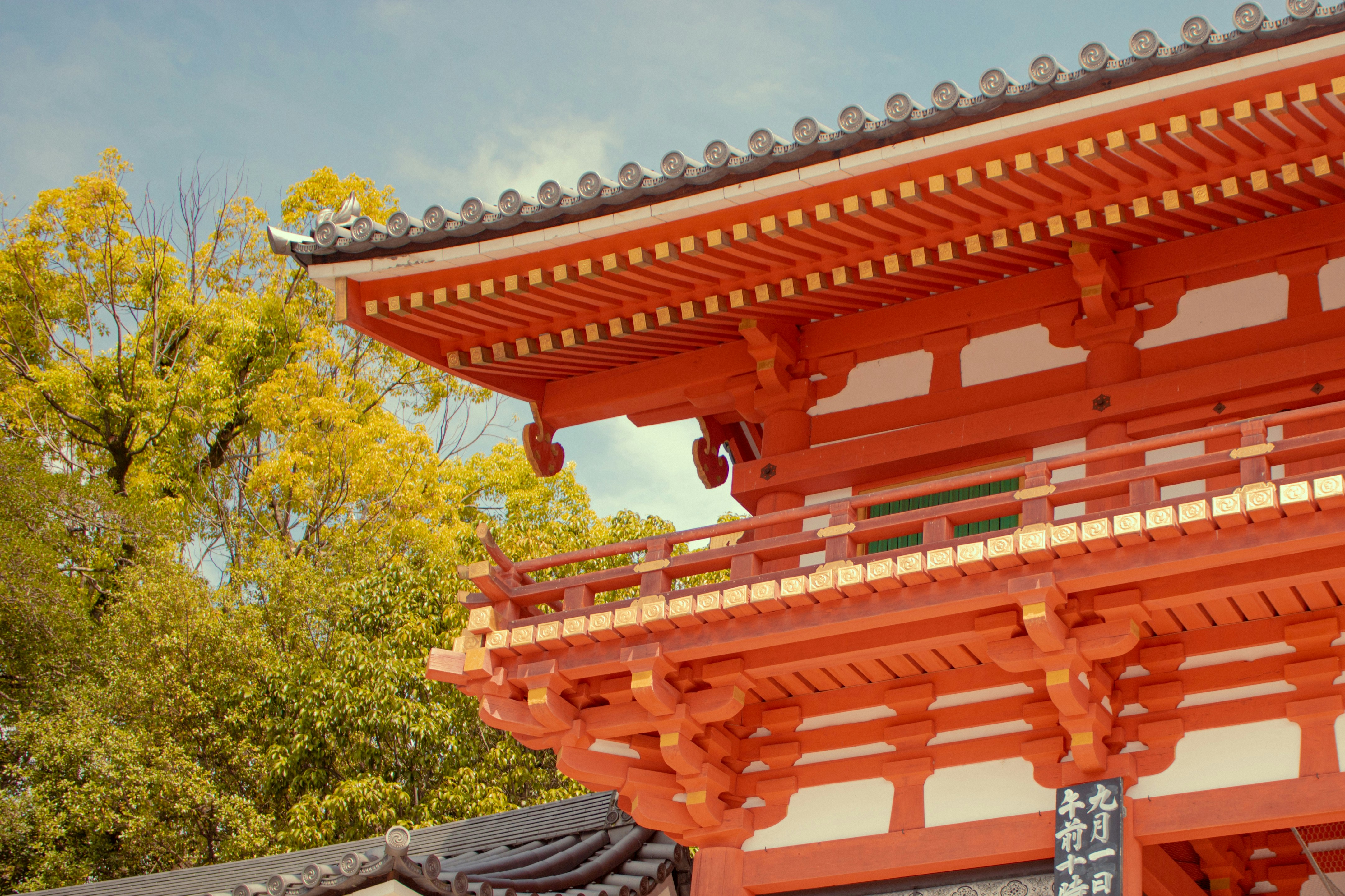 a tall red building sitting next to a forest