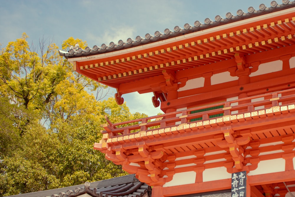 a tall red building sitting next to a forest