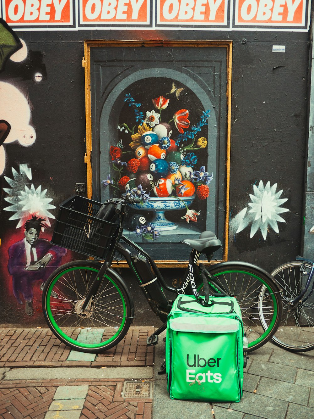 a bike parked next to a building with a painting on it