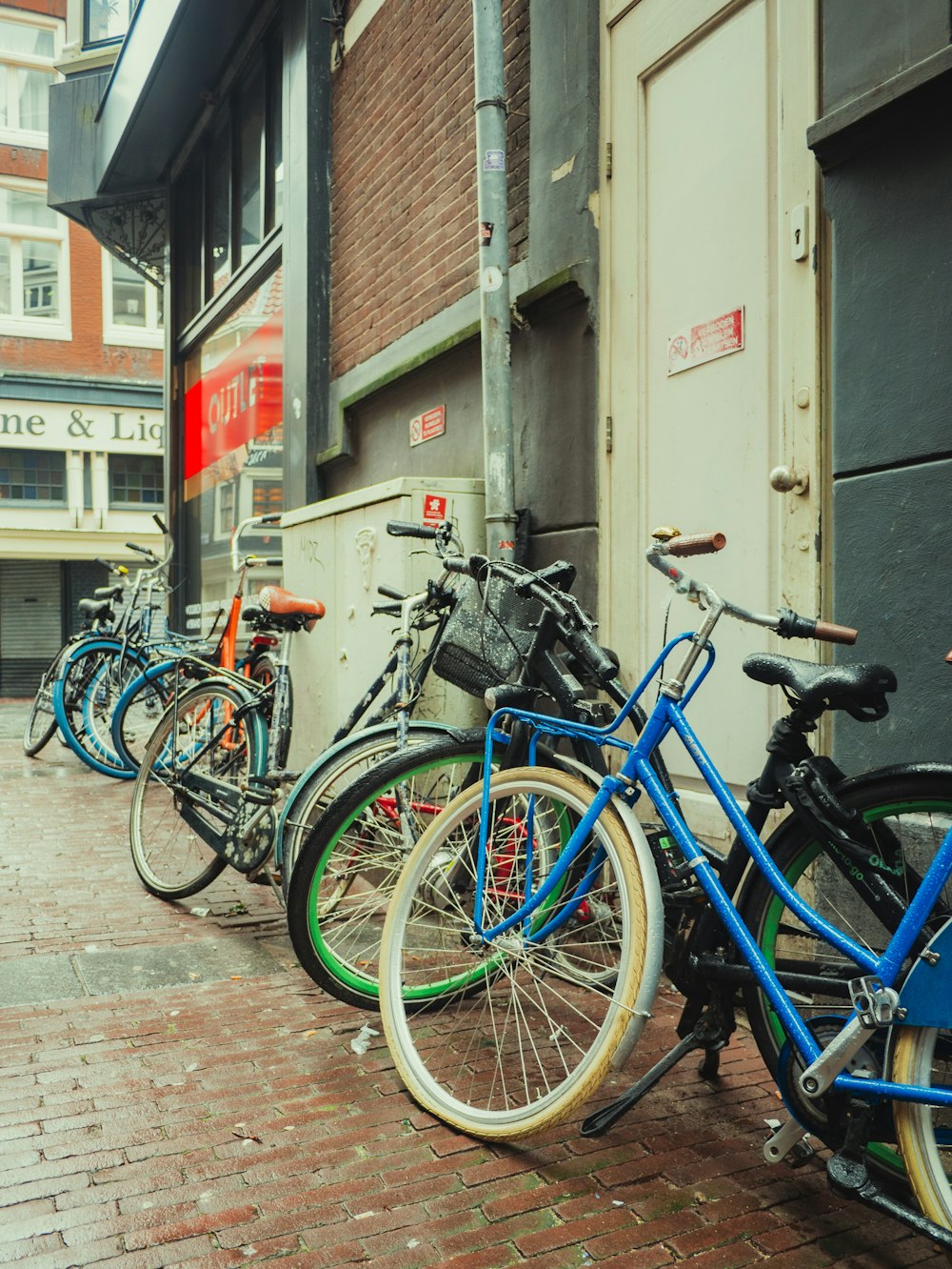 a row of bikes parked on the side of a building