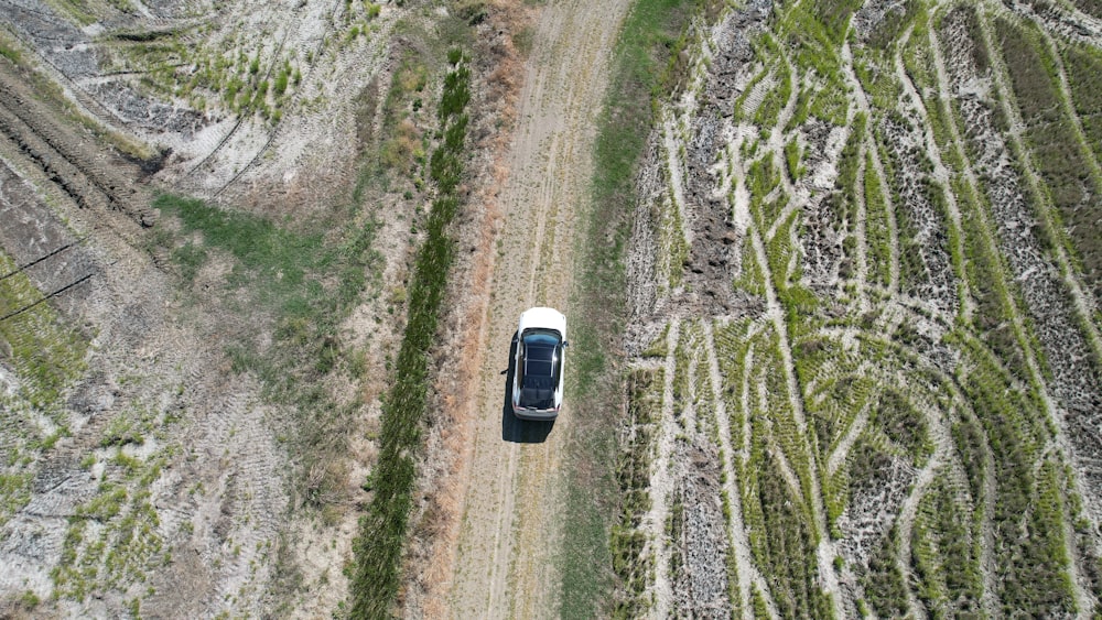 une vue aérienne d’une voiture roulant sur un chemin de terre