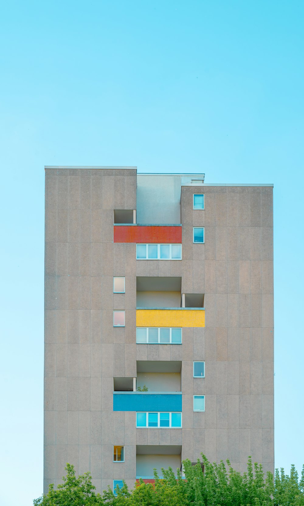 a tall building with multicolored balconies on the side