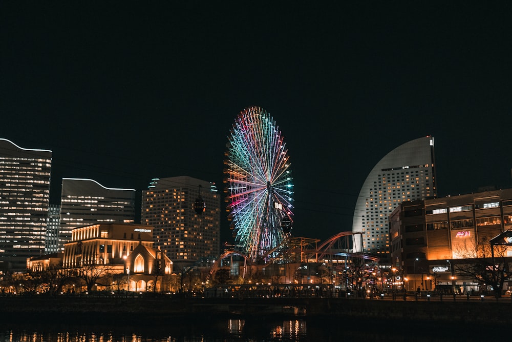 a ferris wheel in the middle of a city at night