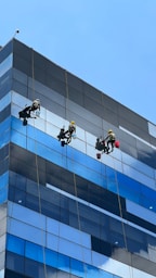 a group of people on a rope in front of a tall building