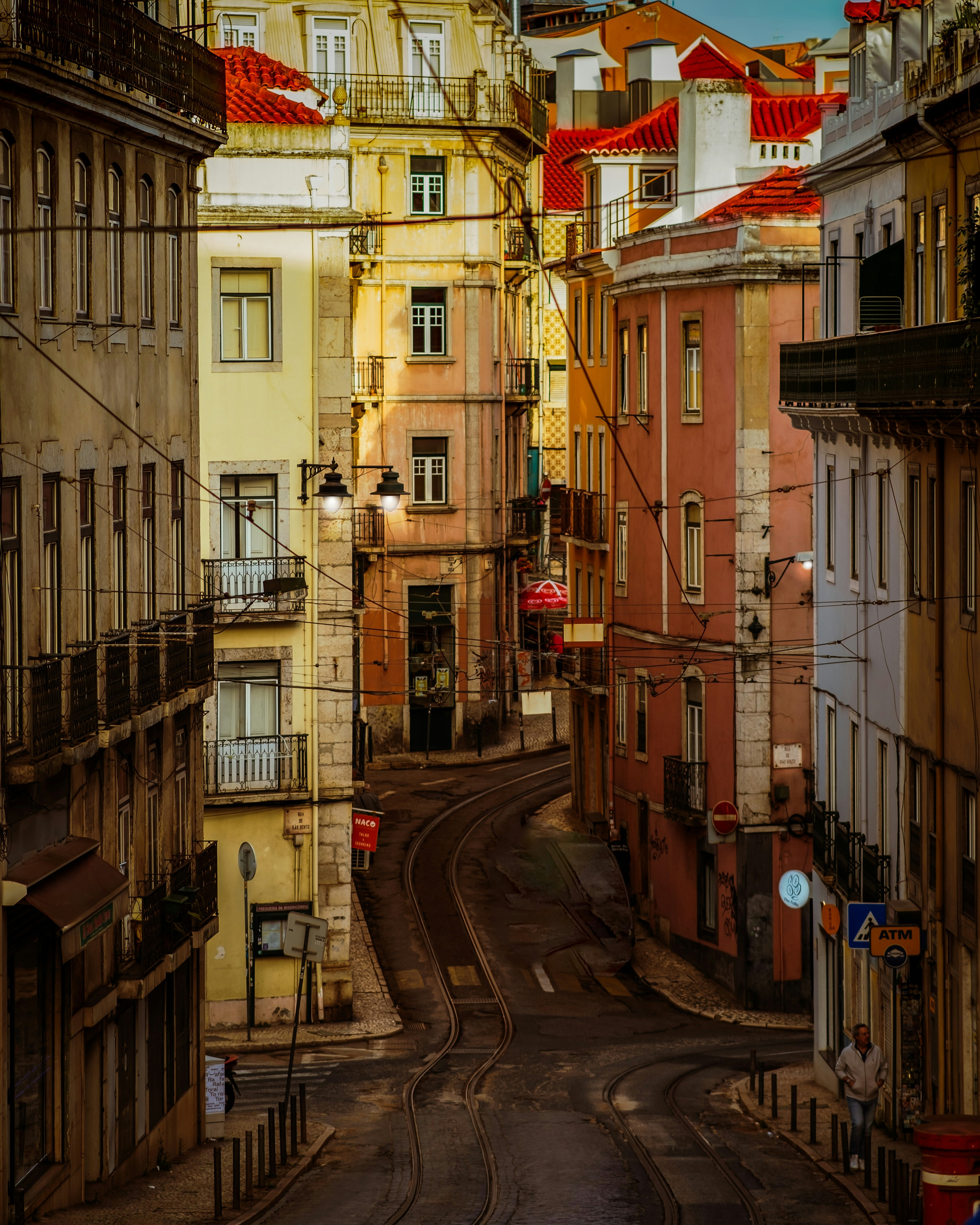 a city street with buildings and a train on the tracks