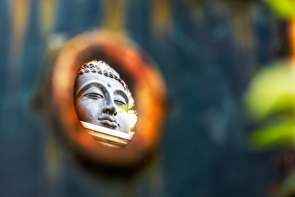 a buddha statue is seen through a circular hole