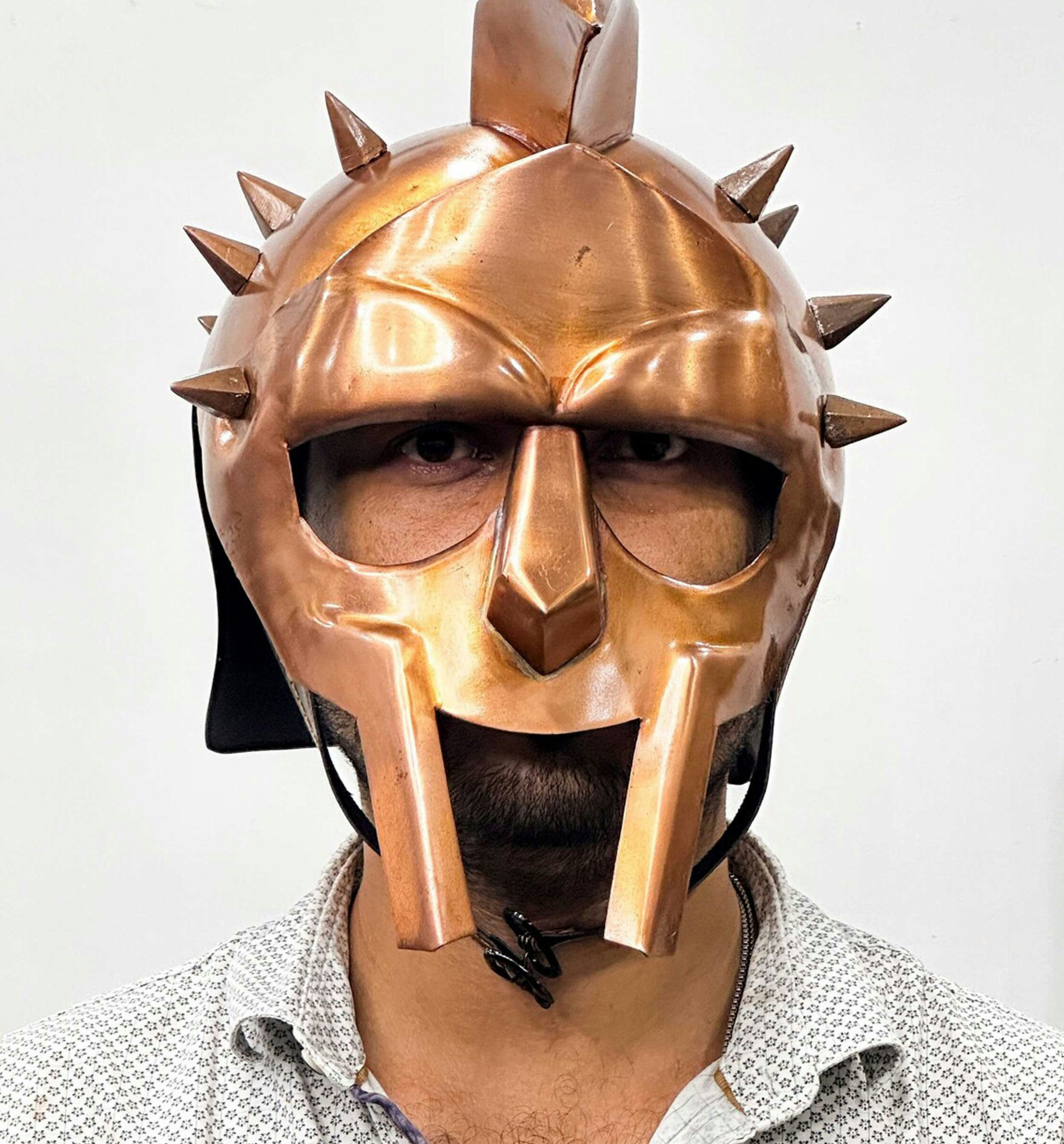 Embark on a journey to the heart of ancient Rome with our Gladiator Maximus Medieval Romans Helmet, an exquisite tribute to the fearless warriors of antiquity. This carefully crafted replica, adorned with a captivating bronze finish, resonates with the grandeur of Roman gladiators. Accompanied by a complimentary wooden stand, it transforms into a striking display piece, capturing the essence of ancient battlefields. Perfect for Halloween or as a distinctive gift, this helmet invites you to relive the tales of valor from a bygone era.