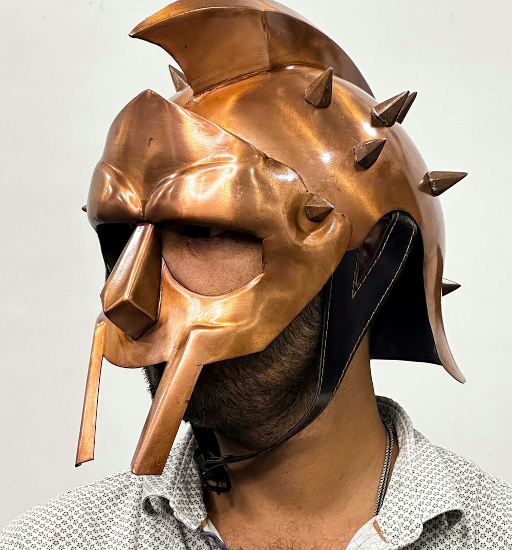 a man wearing a mask with spikes on it