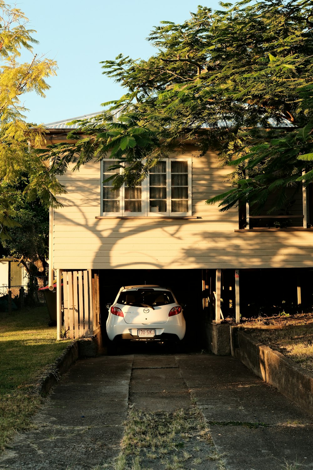 a car is parked in a garage under a tree