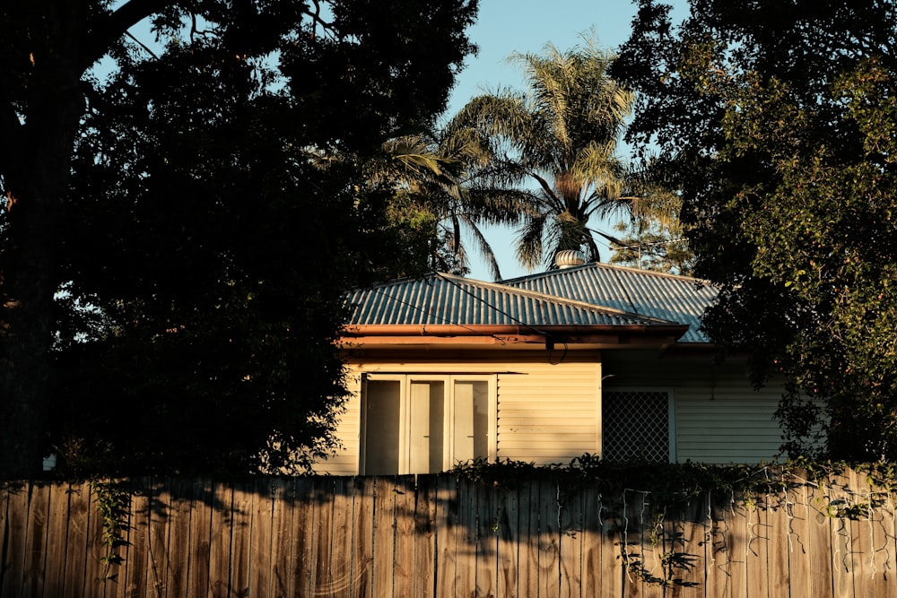 a house with a fence and trees in the background