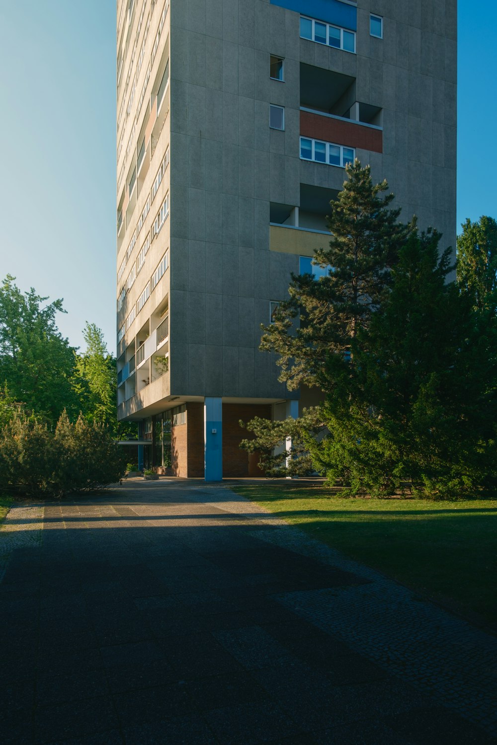 a tall building sitting next to a lush green park