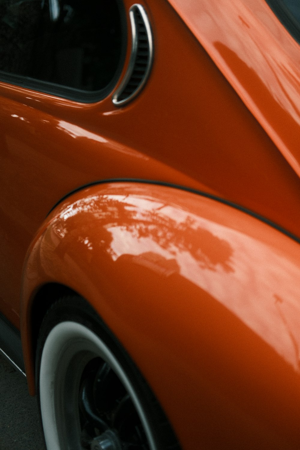 a close up of the front end of an orange car