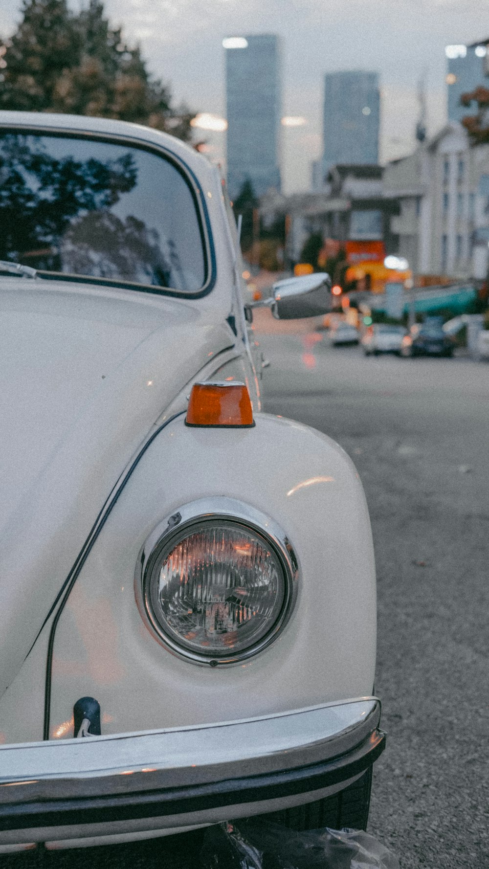 a white vw bug parked on the side of the road