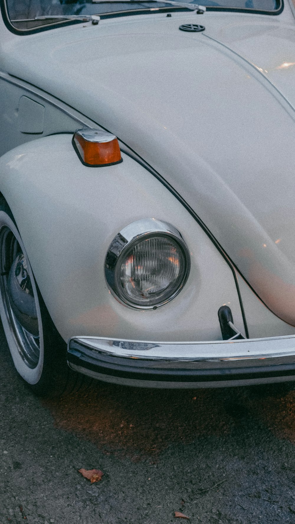 a white vw bug parked in a parking lot