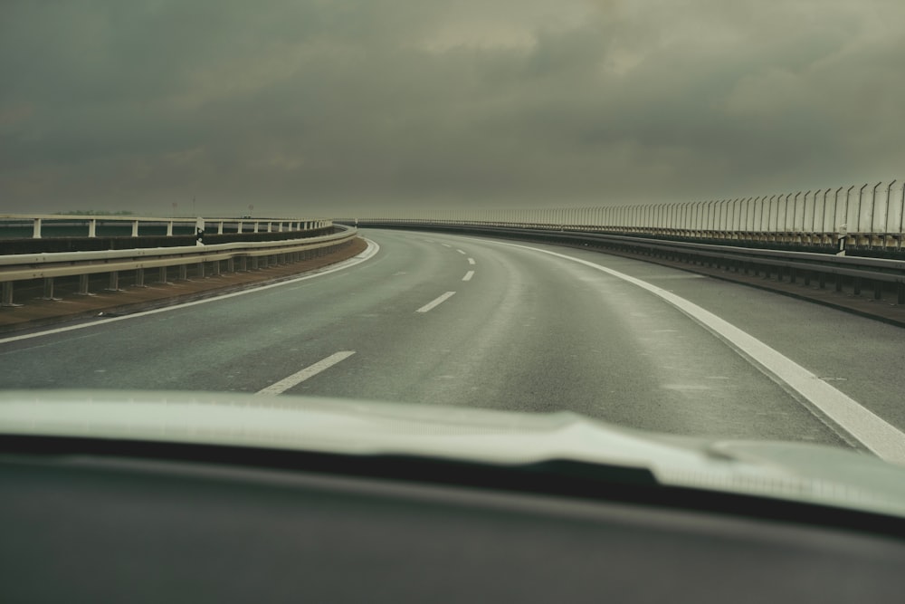 a car driving down a highway under a cloudy sky