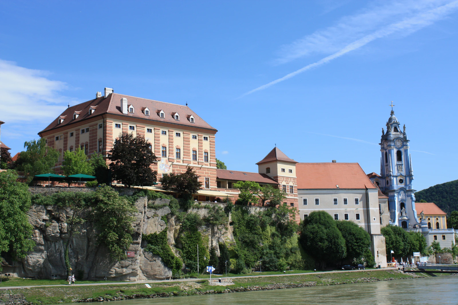 Travel photograph: Dürnstein and its blue abbey tower beside the Danube, seen from the river.