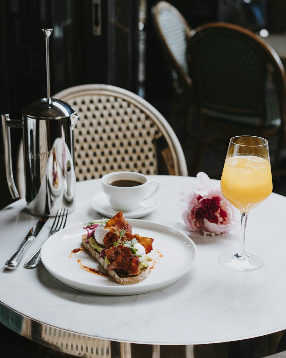 a white plate topped with food next to a glass of orange juice