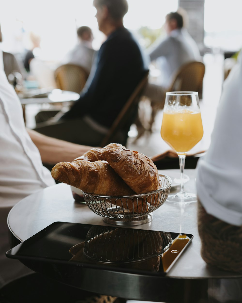 a glass of orange juice and some croissants on a table