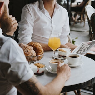 a man sitting at a table with a glass of orange juice