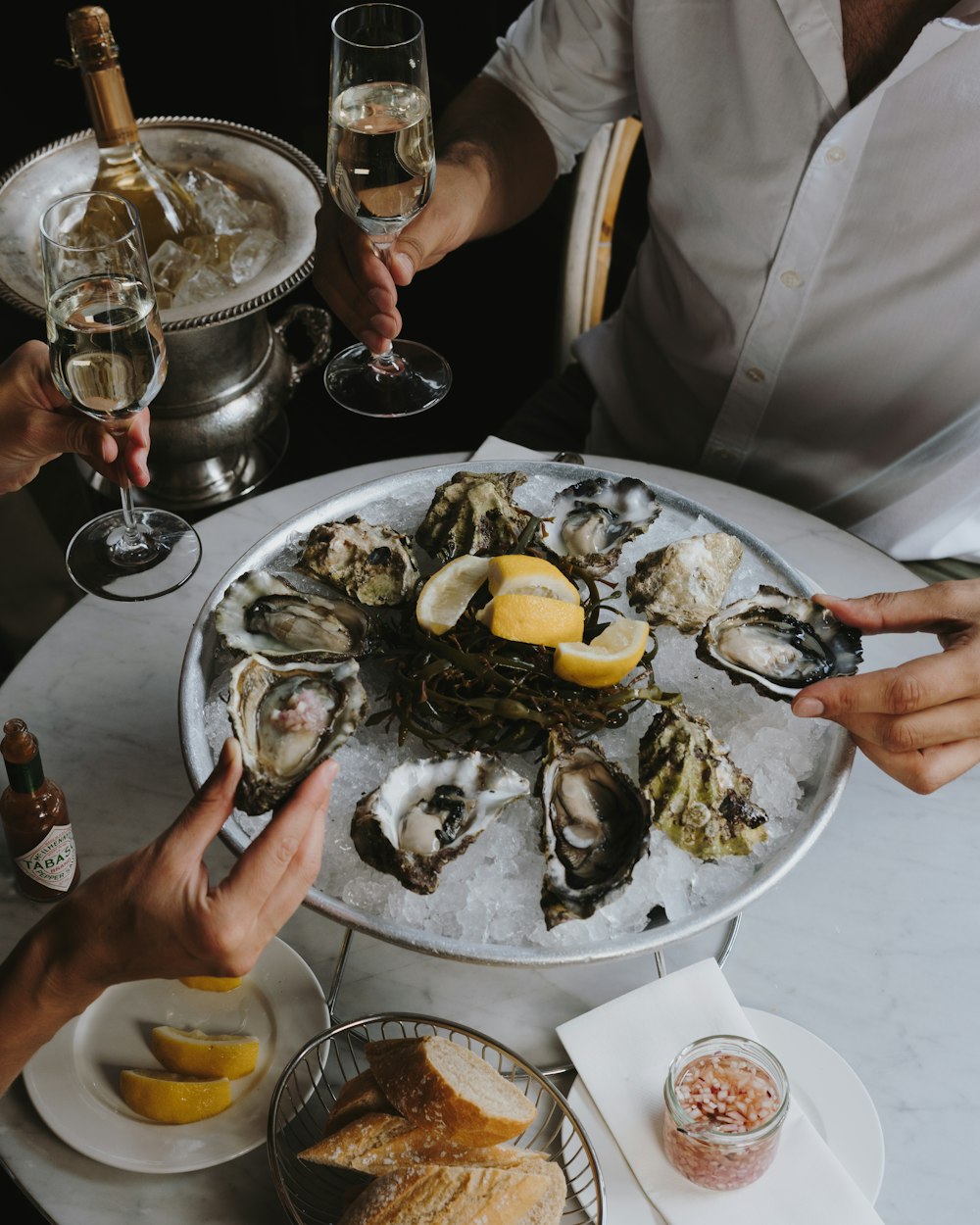 a table topped with oysters and wine glasses