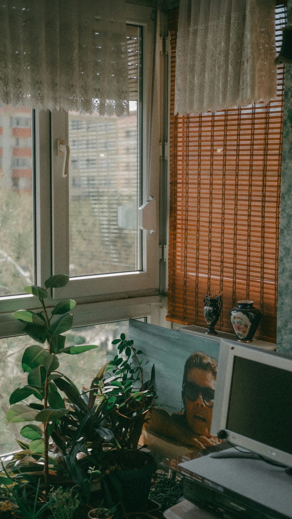 a laptop computer sitting on top of a desk next to a window