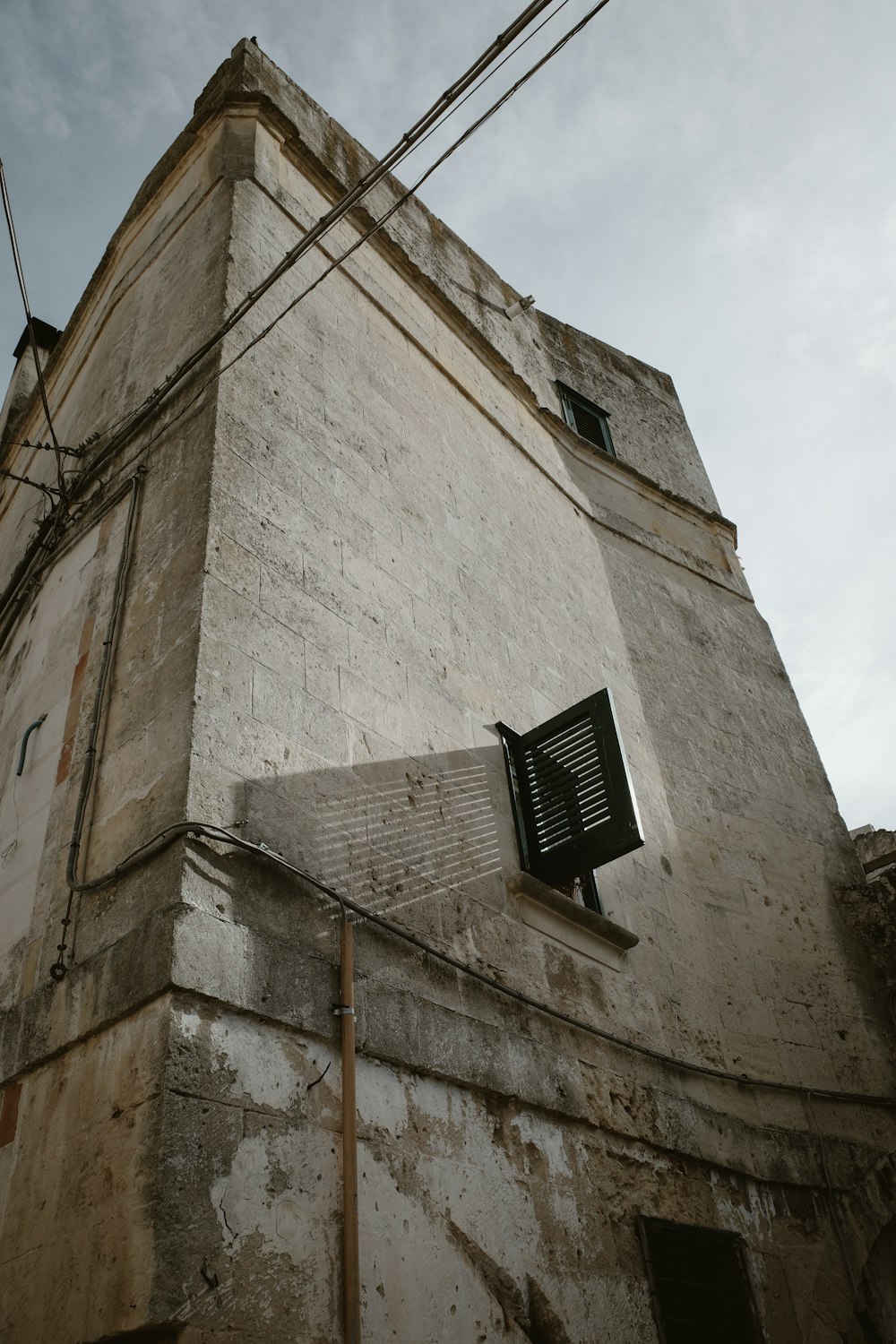 a tall building with a window and a sky background