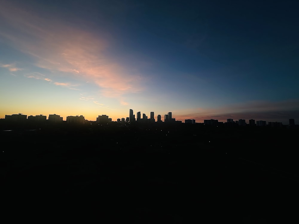 the sun is setting over a city skyline