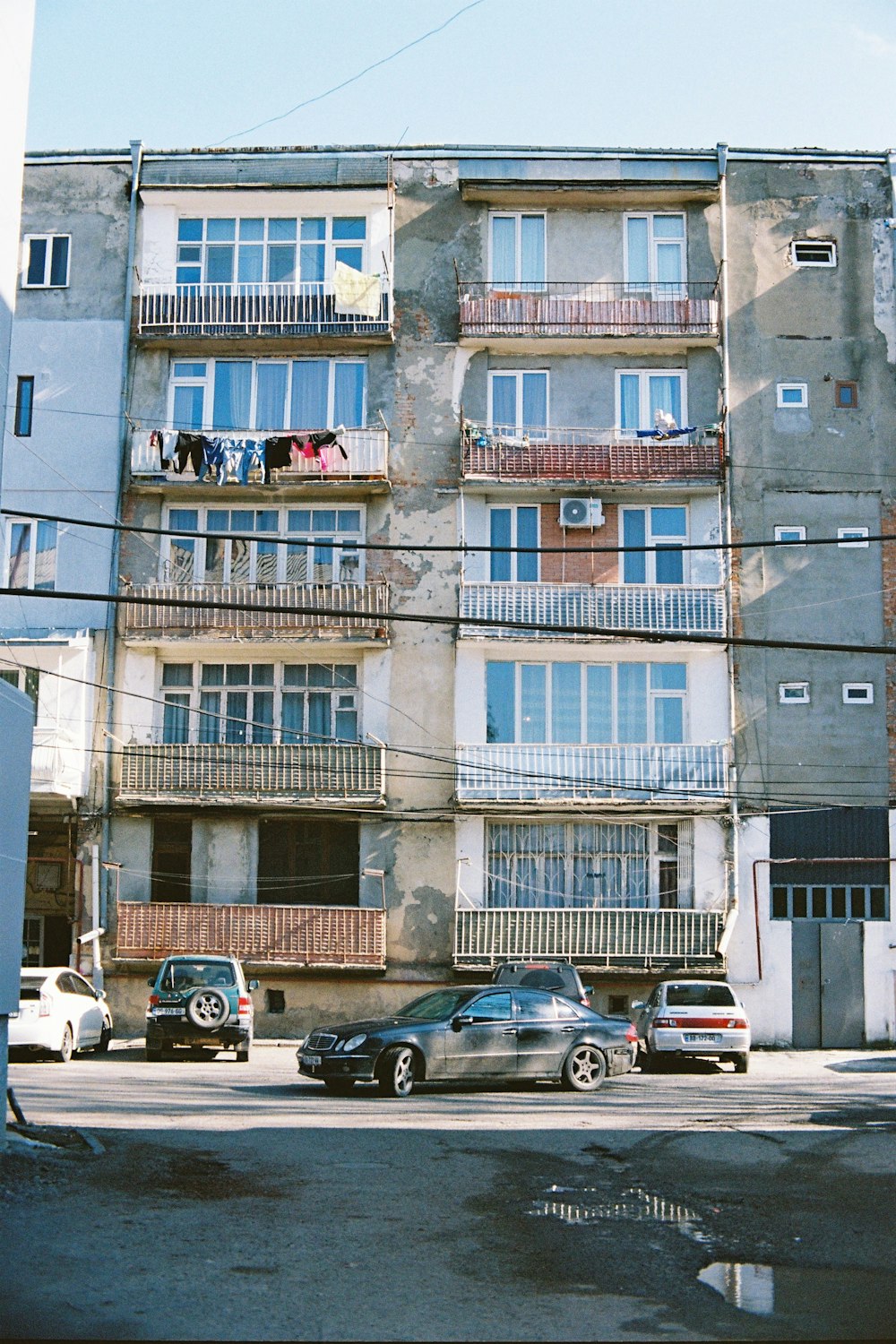 a group of cars parked in front of a tall building