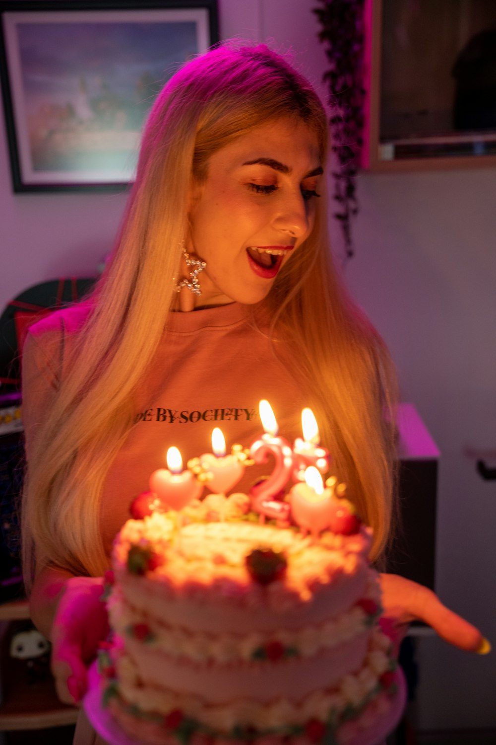 a woman holding a birthday cake with lit candles