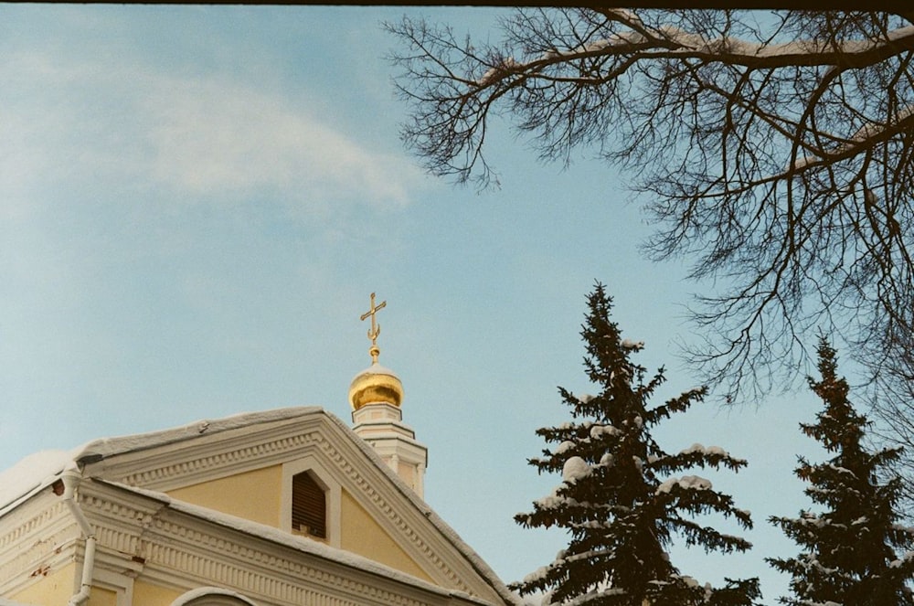 una chiesa con un campanile d'oro e una croce in cima