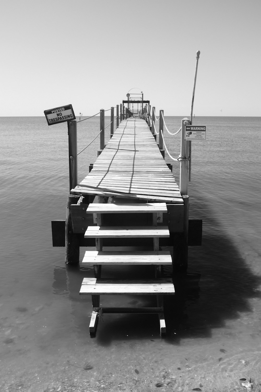 a long dock with benches in the water